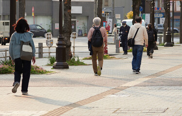 午後の都市の街で歩く人々の姿