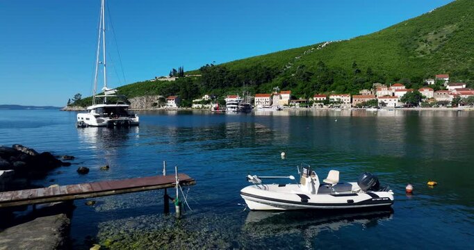 Boats Moor In The Coast With Catamaran And Trstenik Village In Summer In Peljesac Peninsula, Croatia. - aerial shot