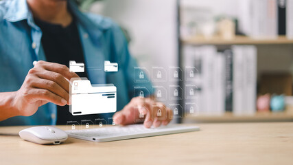 Man using keyboard to manage digital file folders with secure lock icons. Concept of data security,...