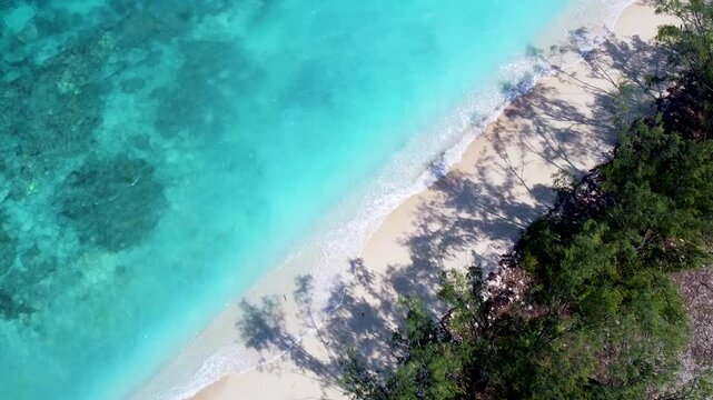 Aerial birds eye view rising over remote Jaco Island in Timor-Leste, white sand beach and crystal clear turquoise ocean water