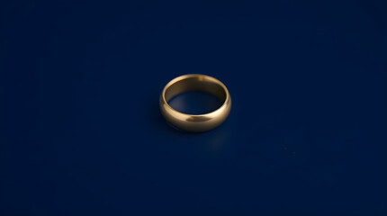 Golden wedding ring shining on dark blue background representing commitment and love