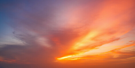 Vibrant fiery sunset over the ocean with silhouettes of cargo ships on the horizon, painting the...