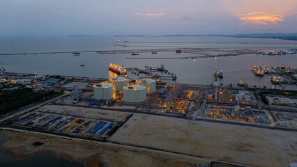Aerial view of an LNG tanker docked at an offshore terminal with multiple pipelines, storage tanks,...