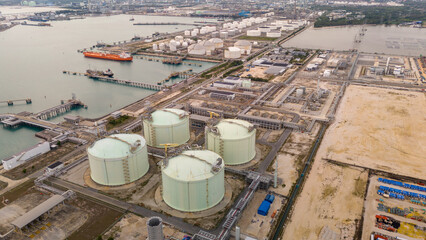 LNG storage tanks and terminal facility at dusk, showcasing large cylindrical containers, offshore...