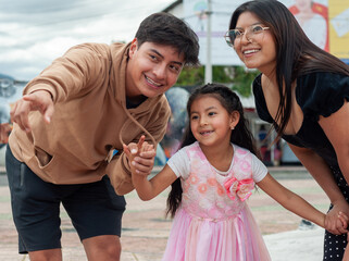 Happy latin american family pointing and smiling outdoors