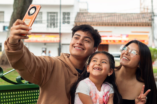 Happy latin american family taking a selfie in a park