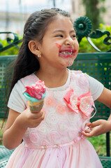Happy girl eating ice cream cone and making a mess