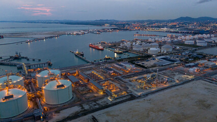 LNG tanker docked at an offshore terminal with multiple pipelines, storage tanks, and an industrial complex. Captures global energy logistics © Yellow Boat