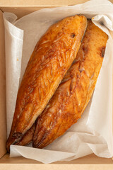Honey glazed smoked mackerel fillets in a brown cardboard box lined with greaseproof paper. Recycle biodegradable eco friendly retail packaging.