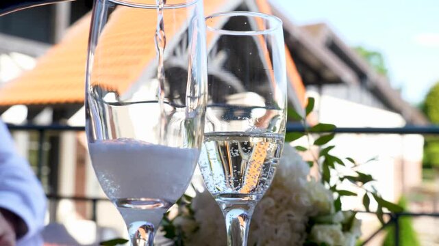 White sparkling champagne is poured into glasses. Alcohol consumption culture.