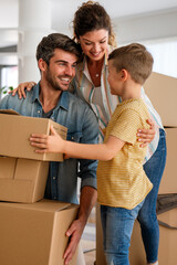 Moving, parents and child in new home bonding together, unpacking boxes for family time