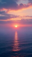Fototapeta premium Sun sets over the ocean with colorful clouds in the sky