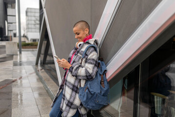 Stylish freelancer enjoying music and working remotely in urban setting