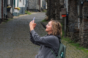 Tourist takes photos of old European cities with a smartphone