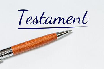 Symbolbild Testament: Kugelschreiber auf weißem Blatt mit hinzugefügtem Text TESTAMENT