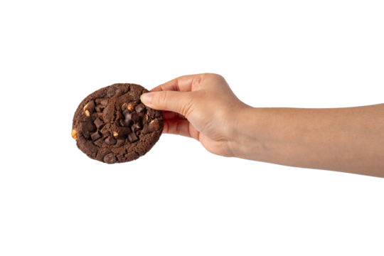 A large chocolate cookie topped with chocolate chips and hand, set against a transparent background.