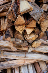 Close-up of stacked firewood with rough-textured bark and cut wooden logs