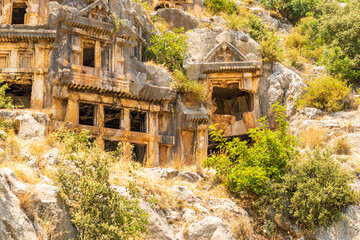 Naklejka premium Demre, Turkey - June 14, 2025:View of the ancient Lycian necropolis and Roman amphitheater in the ruins of Myra, located in Demre, Antalya Province, Turkey.