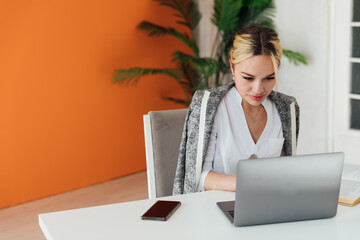 woman sitting at office desk and working on laptop online