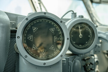 A detailed close-up of an old ship's compass alongside a speed gauge measured. These vintage...