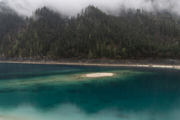 Jiuzhaigou, China: Dramatic view of the long lake on a foggy spring morning in the famous jiuzhaigou scenic area in the mountain of Sichuan in China