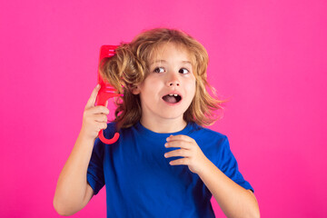 Funny kids hairstyle. Little kid combing hair, isolated studio background.