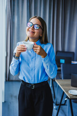 A Joyful Businesswoman is taking a delightful coffee break while enjoying a moment of relaxation in a modern office setting, embodying professionalism and enthusiasm amid her busy work life