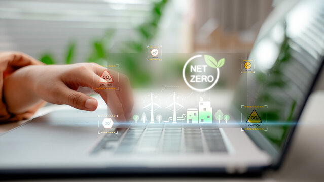 Person working on laptop with virtual Net Zero and CO2 emission icons, representing ESG strategy, carbon footprint analysis, and environmental sustainability in modern business.