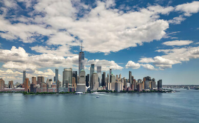 Obraz premium NYC aerial skyline, New York. Panorama view of New York city skyscrapers on blue sky. USA NYC. Lower NYC skyline on sunny day. New York cityscape. New York City with clouds from drone.