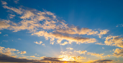 Fototapeta premium Sky at sunset. Sunrise over horizon. Sunlight shining through clouds on sky. Twilight sky with vibrant colors. Peaceful dawn with soft light. Dramatic dusk with glowing clouds. Sunshine in clear sky.
