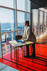 A dedicated business professional gazes out at the skyline from their office, reflecting their aspirations, ambition, and strong motivation to succeed and achieve their career goals