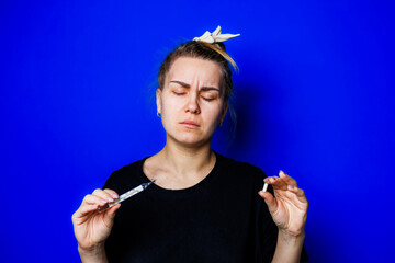A thoughtful woman holds a syringe in one hand and a cigarette in the other, set against a vibrant...