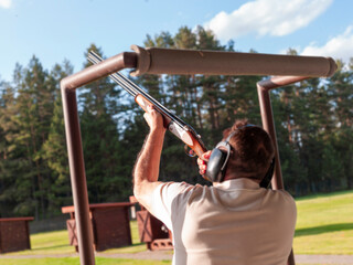 man practicing on clay target shooting