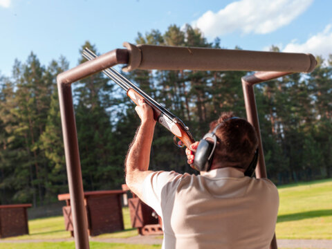 man practicing on clay target shooting