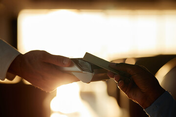 Waiter holding payment terminal while customer making contactless payment with credit card in...