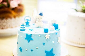 sponge cake with blue mastic and a sweet teddy bear on top. children's party. happy birthday