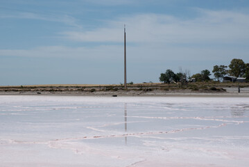 Pink lake with salt sand and mineral deposits under clear sky