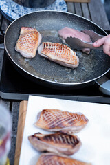 Preparing of grilled juicy fillet of duck for dinner. Chef fry meat on frying pan for main meal during barbecue. Delicious slices of meat. Food ready to eat.