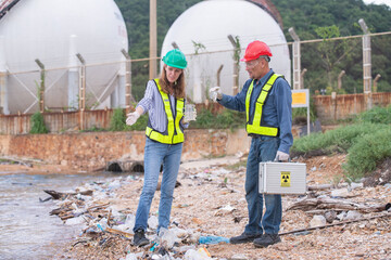 Environmental engineer or workers examining waste water along a large industrial waste water or...
