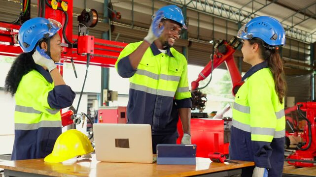 Workers or engineers giving hi five pose and clapping hands from success work or project in robot factory