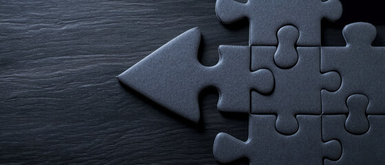 Black Puzzle Pieces with Arrow Shape on Dark Background for Creative Solutions Concept