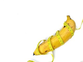 Fresh banana with tape measure on white background, copy space. Healthy lifestyle concept 