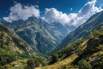 Obraz premium A sun-drenched valley nestled between imposing mountain ranges, showcasing a vibrant mix of lush greenery and rocky peaks under a partly cloudy sky