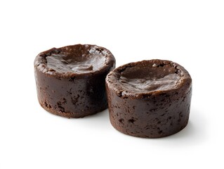 A close up shot of two dark chocolate lava cakes on a white surface with a plain background visible here