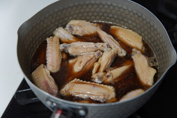 	鶏手羽中の煮物を作る様子