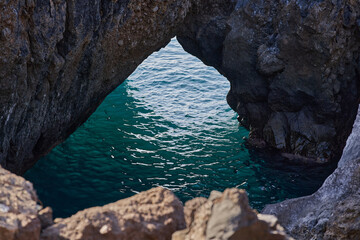 Turquoise sea through rock arch