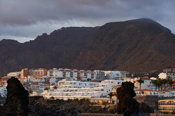 Coastal view of Los Gigantes with colorful houses and resorts perched above volcanic cliffs and the...