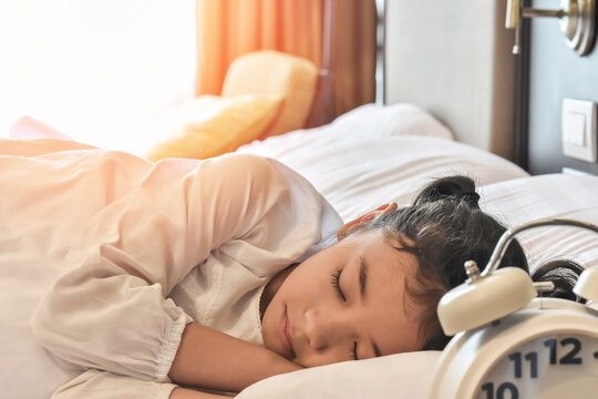 Little girl child sleeping well on bed at bedtime night. Toddler sleeps in bedroom at home, healthy lifestyle of Asian school kid student dreamer deep sleep relaxation at night in bed room hotel