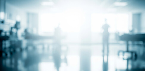 Blurred hospital interior with figures and beds in a bright light setting.