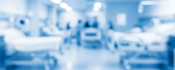 Blurred hospital room interior with beds and medical equipment in a light blue tone.
